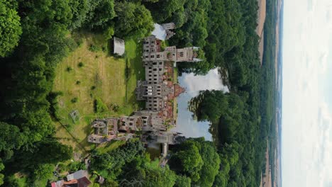 Vertical-shot-of-old-palace-in-the-middle-of-the-forest,-Kopice,-Poland--4K-video