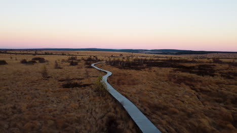 Gewundener-Weg-Durch-Natürliches-Flachland-Bei-Sonnenuntergang,-Luftaufnahme