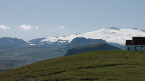 Iglesia-Ingjaldshólskirkja-En-Green-Hill,-Glaciar-Nevado-En-El-Fondo,-Panorámica-A-La-Derecha