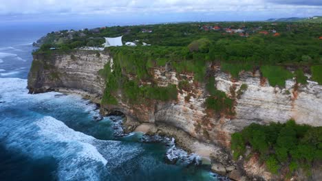 Uluwatu-Cliffs-With-Ocean-View-And-Waves-In-Bali,-Indonesia---aerial-pullback
