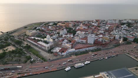 Drone-Vuela-Sobre-El-Paisaje-Urbano-De-Cartagena-Colombia-Revelando-El-Centro-Histórico-De-La-Ciudad-Colonial-Y-Su-Muralla-Al-Atardecer-Con-La-Costa-Del-Mar-Caribe