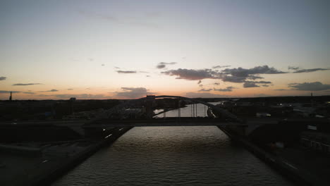 Silhouette-of-city-and-bridge-during-sunset,-aerial-drone-view