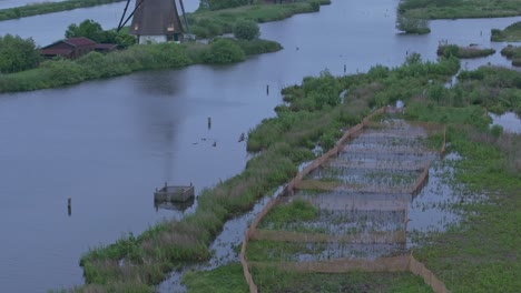 Tilt-up-shot-of-Kinderdijk-Holland-famous-windmills-with-clouds,-aerial