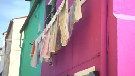 Clothes-hanging-from-a-window,-a-pink-house,-a-green-house,-Murano-and-Burano-islands,-from-bottom-to-top