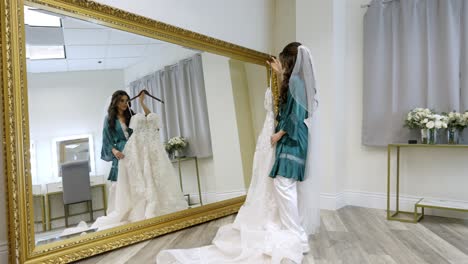 Eine-Wandernde-Aufnahme,-Während-Eine-Braut-Sich-Vorstellt,-Wie-Sie-An-Ihrem-Hochzeitstag-Ein-Hochzeitskleid-Trägt,-Während-Sie-In-Den-Spiegel-Schaut