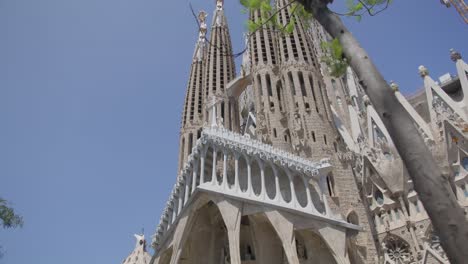 Baum-Weht-Im-Wind,-Blick-Auf-Den-Himmel,-Die-Berühmte-Kathedrale-Sagrada-Familia-In-Barcelona,-Spanien,-Am-Frühen-Morgen-In-6-Km