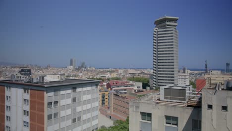 Vista-De-Cerca-Del-Gran-Edificio,-Visión-General-De-Barcelona-España-Temprano-En-La-Mañana-Mientras-Los-Pájaros-Vuelan-A-Lo-Largo-Del-Horizonte-De-La-Ciudad-En-6k