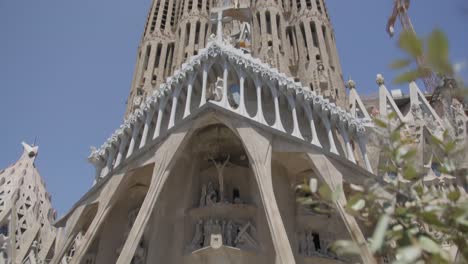 People-on-Street-to-High-Sky-Pan-View,-The-Famous-Sagrada-Familia-Cathedral-in-Barcelona-Spain-in-the-Early-Morning-in-6K