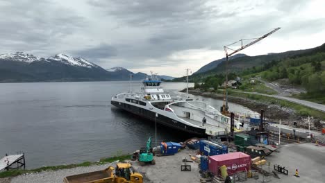 Construction-work-at-ferry-pier-while-ferry-Rodvensfjord-alongside---Infrastructure-maintenance-and-improvment-Norway---Aerial