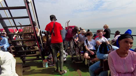 Caminando-Entre-Una-Multitud-De-Pasajeros-En-La-Cubierta-De-Un-Ferry-Que-Navega-Desde-Banjul-A-Barra-En-Gambia