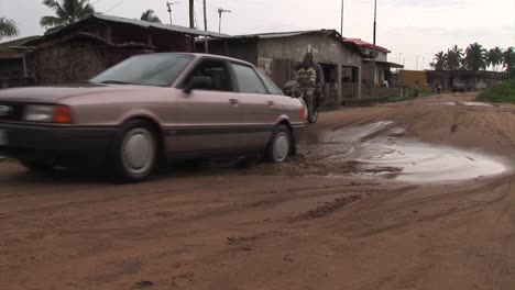 Car-and-motorbike-driving-through-a-huge-puddle-in-Nigeria