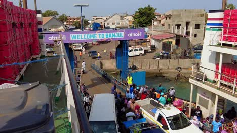 Toma-De-ángulo-Alto-De-Un-Ferry-Que-Sale-De-Banjul-A-Barra---Terminal-De-Ferry-De-Banjul,-Autoridad-Portuaria-De-Gambia,-Gambia-En-Un-Día-Soleado