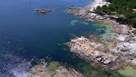 Aerial-Drone-Footage-of-Stunning-Rocky-Shoreline-Visible-Seabed-with-Vegetation