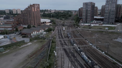 Drone-Shot-of-Freight-Train-Leaving-Leeds-Train-Station-in-Low-Light-at-Morning