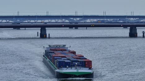 Luftdrohnenaufnahme-Des-Frachtschiffs-Alfa-Menta,-Das-Anmutig-Durch-Das-Wasser-Segelt,-In-Der-Nähe-Der-Moerdijk-Brücken,-Niederlande