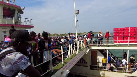 Kunta-Kinteh-ferry-boat-crossing-the-River-Gambia-in-Africa-with-passengers-on-top-deck-and-captain-bridge-in-background