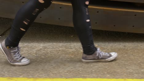 Zerschlissene-Schuhe-Und-Kleidung,-Die-über-Den-Bürgersteig-Eines-Industriegeländes-Laufen
