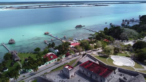 Bacalar-Yucatan-aerial-view-of-blue-lagoon-with-luxury-resort-in-Yucatan-state-Mexico-,-drone-fly-above-san-Felipe-castle-fortress