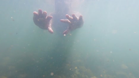 Hombre-Hundiéndose-En-Agua-Sucia-De-La-Vista-Submarina-Del-Río-Con-Rayos-De-Sol-Por-La-Mañana