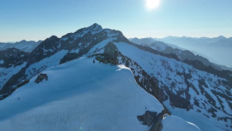 Circling-drone-orbit-shot-around-a-jagged-summit-overlooking-a-glacier-in-Austria's-breathtaking-Alps-mountain-range