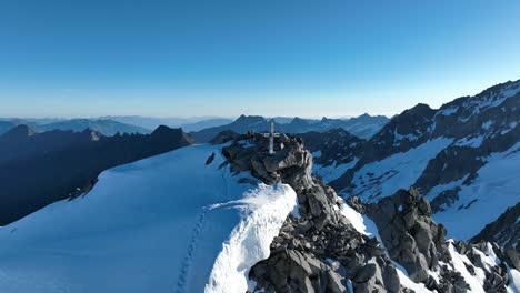Drone-footage-circling-around-a-rugged,-craggy-summit-near-a-glacier-in-the-scenic-Austrian-Alps-mountains