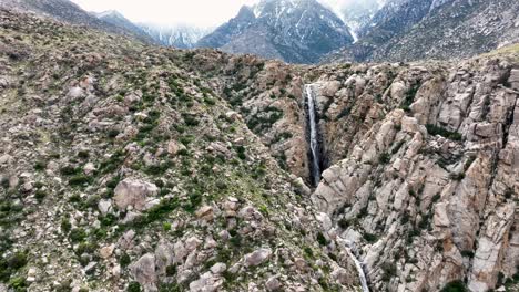 Zurückschieben-Blick-Auf-Den-Wasserfall-Mit-Bergen-Im-Hintergrund-Und-Schnee-In-Der-Wüste-Ca