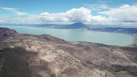 This-compelling-drone-footage-reveals-a-stunning-aerial-journey-from-the-mountains-to-the-vast,-serene-expanse-of-Lake-Chapala-in-Jalisco,-Mexico