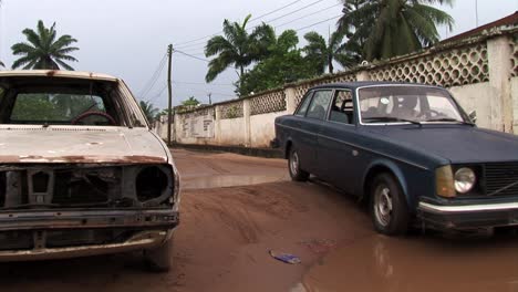 Coche-Viejo-Se-Detiene-Ante-Un-Enorme-Charco-En-Una-Carretera-En-Nigeria
