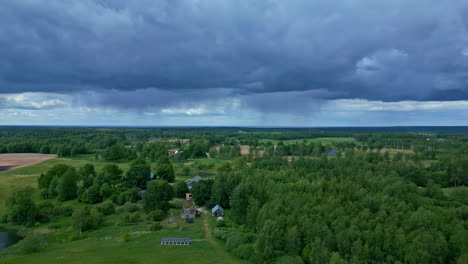 Aerial-drone-view-of-a-green-landscape-and-rain-falling-in-the-distance