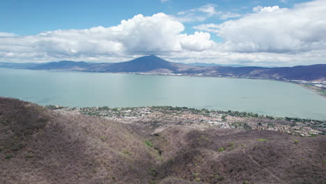 This-compelling-drone-footage-reveals-a-stunning-aerial-journey-from-the-mountains-to-the-vast,-serene-expanse-of-Lake-Chapala-in-Jalisco,-Mexico