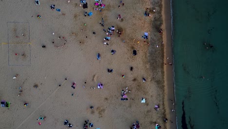 Overhead-shot-of-a-vibrant-beach-scene-in-Malta-captured-by-a-drone-camera-showing-tourists-relaxing-and-having-fun
