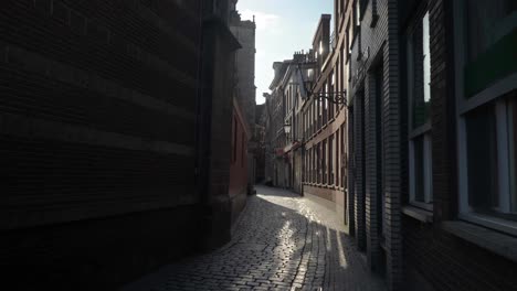Sunlight-glimmers-in-shadow-alley-way-of-Oudekerkplein-Amsterdam-Red-Light-District-De-Wallen