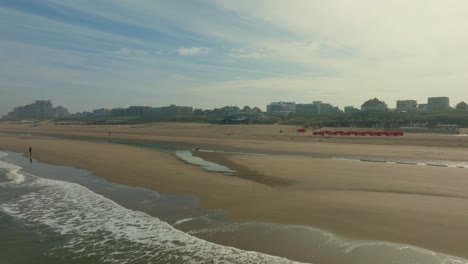 Low-drone-shot-of-the-empty-beach-at-Noorwijk-in-the-morning