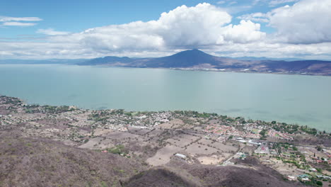Diese-Fesselnden-Drohnenaufnahmen-Zeigen-Eine-Atemberaubende-Flugreise-Von-Den-Bergen-Zur-Riesigen,-Ruhigen-Fläche-Des-Chapala-Sees-In-Jalisco,-Mexiko