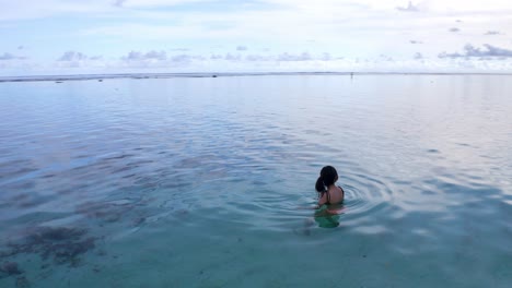 Eine-Frau-Im-Bikini-Schwimmt-Am-Gunung-Umbrella-Beach,-Bali,-Indonesien