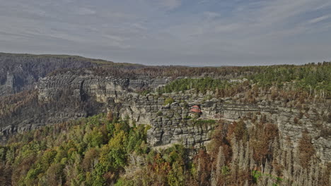 Hrensko-Czechia-Aerial-v1-cinematic-drone-reverse-flyover-hillside-capturing-rocky-mountain-landscape-with-views-of-burnt-forest-and-landmark-Pravcicka-Archway---Shot-with-Mavic-3-Cine---November-2022