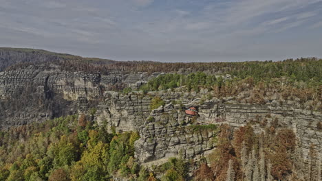 Hrensko-Czechia-Aerial-v2-drone-flyover-capturing-spectacular-natural-sandstone-arch-Pravcicka-Archway-and-Falcon's-nest-Hotel-Sokolí-hnízdo-on-the-rocky-cliff---Shot-with-Mavic-3-Cine---November-2022