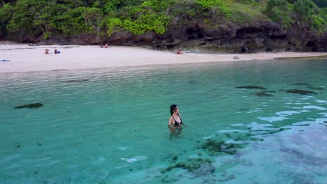 A-Woman-On-The-Turquoise-Ocean-Of-Gunung-Payung-Beach-In-Bali,-Indonesia