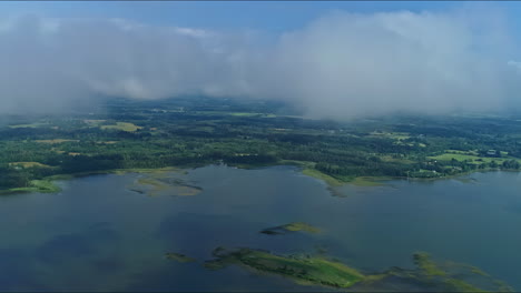 time-lapse-of-misty-clouds-shrouding-a-large-waterway-surrounded-by-lush-countryside