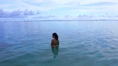 A-Woman-Traveler-Swims-On-Crystal-Clear-Beach-Of-Gunung-Payung-In-Bali,-Indonesia
