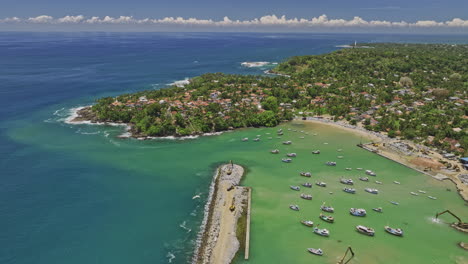 Gandara-Sri-Lanka-Aerial-v3-drone-flyover-fishermen-harbour-towards-residential-neighborhood-capturing-sandy-beach,-fishing-boats-and-Indian-ocean-on-a-sunny-day---Shot-with-Mavic-3-Cine---April-2023