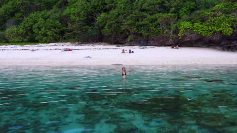 Mujer-Turista-Nadando-En-Las-Aguas-Cristalinas-De-La-Playa-De-Gunung-Payung-En-Bali,-Indonesia