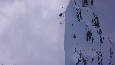 Weite,-Hohe-Luftaufnahme-Des-Schneebedeckten-Bergrückens-Und-Der-Spuren-Eines-Bergsteigers-In-Einer-Weißen-Decke