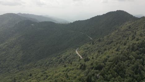 Highway-winds-along-forest-mountain-side-toward-summit-ridge-viewpoint
