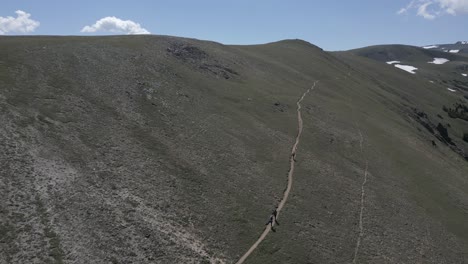 Hikers-walk-trail-on-barren-summit-ridge-slope-near-Telluride-Colorado