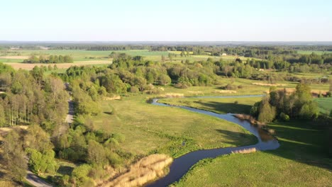 Gewundener-Fluss-Durch-Das-Flachland-Lettlands-An-Sonnigen-Tagen,-Luftaufnahme-Des-Abstiegs