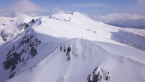 Lone-climber,-skier-stands-on-summit-of-Parang