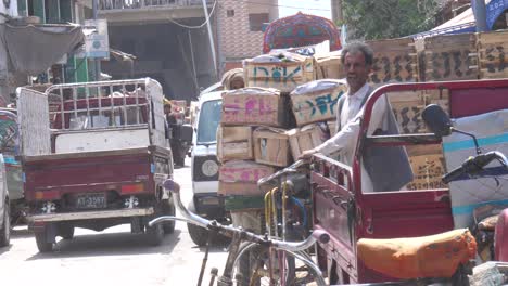 Zeitlupenaufnahme-Eines-Arbeiters,-Der-An-Einem-Sonnigen-Tag-Früchte-Auf-Seinem-Fahrradkarren-Vom-Großhandelsobstmarkt-In-Karachi-In-Pakistan-Mitnimmt