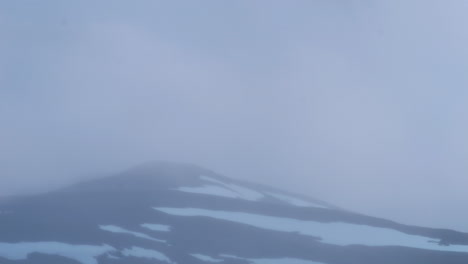 Clouds-flowing-above-snowy-mountain-in-Sweden,-time-lapse-view