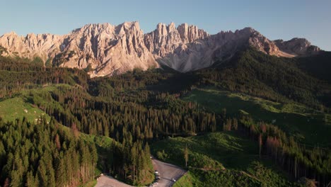 Aerial-view-of-Carezza-lake-with-Dolomites-mountain-peak-in-background,-Italy